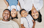 Happy mixed race family with two children lying on floor together and bonding at home from above. Little brother and sister spending time with their parents