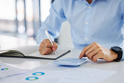 Closeup of an unknown businessman using his calculator while working on paperwork