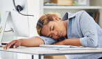 One exhausted african american call centre agent sleeping in an office. Businesswoman feeling overworked, tired and demotivated while operating helpdesk. Lazy consultant slacking and ignoring clients by taking a nap. Burnout and stress in workplace