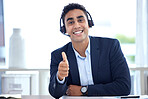 Portrait of one happy smiling mixed race call centre telemarketing agent gesturing thumbs up for approval and success while wearing headset in an office. Confident and friendly salesman assistant satisfied with giving good customer service