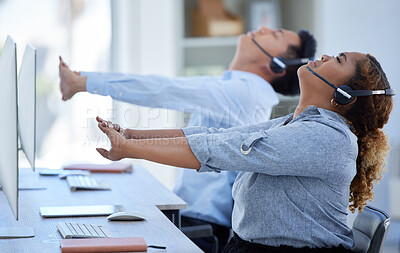 Two call centre telemarketing agents stretching their arms and necks while working in an office. African american assistant taking a break to get ready to operate helpdesk for customer service and sales support alongside a colleague