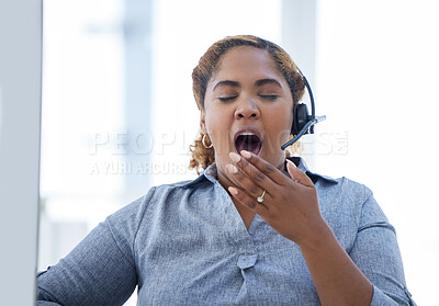 One african american call centre telemarketing agent yawning while working on a computer in an office. Businesswoman feeling tired, bored and lazy while having a slow day at work