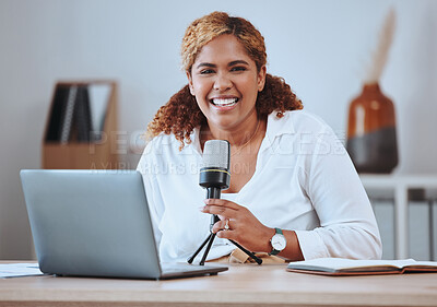 Portrait of smiling young mixed race female presenter using a mic and wireless laptop while doing her podcast sitting at home. Hispanic female blogger using equipment for her social media podcast