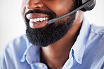 Closeup of one happy african american call centre telemarketing agent with big smile talking on headset while working in office. Face of confident friendly businessman operating helpdesk for customer service and sales support