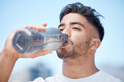 Buy stock photo Man, fitness and drinking water in city for sustainability after running exercise, workout or training outdoors. Thirsty male person, athlete or runner with drink for hydration, rest or break in town