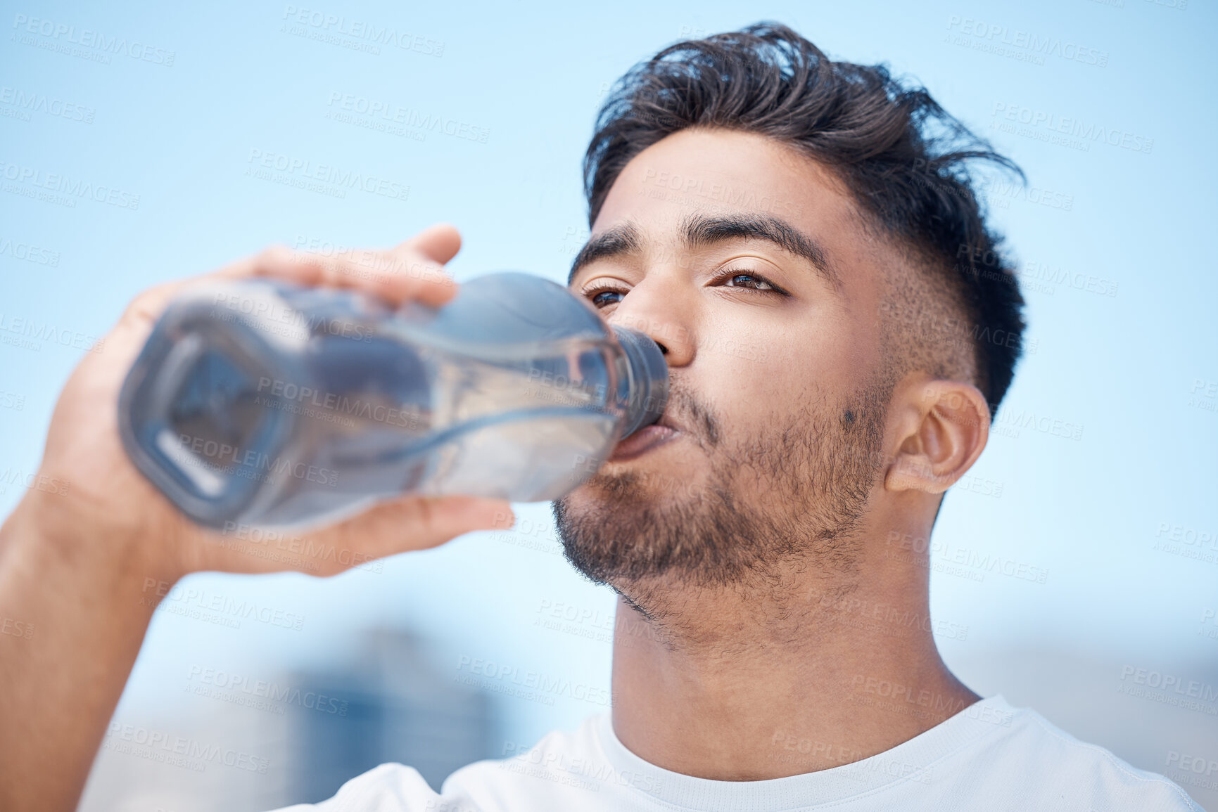 Buy stock photo Man, fitness and drinking water in city for sustainability after running exercise, workout or training outdoors. Thirsty male person, athlete or runner with drink for hydration, rest or break in town