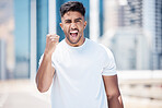Young mixed race male athlete celebrating a goal, making a winner gesture with clenched fist and shouting after a run in the city. Cheerful fit man celebrating after a workout outdoors