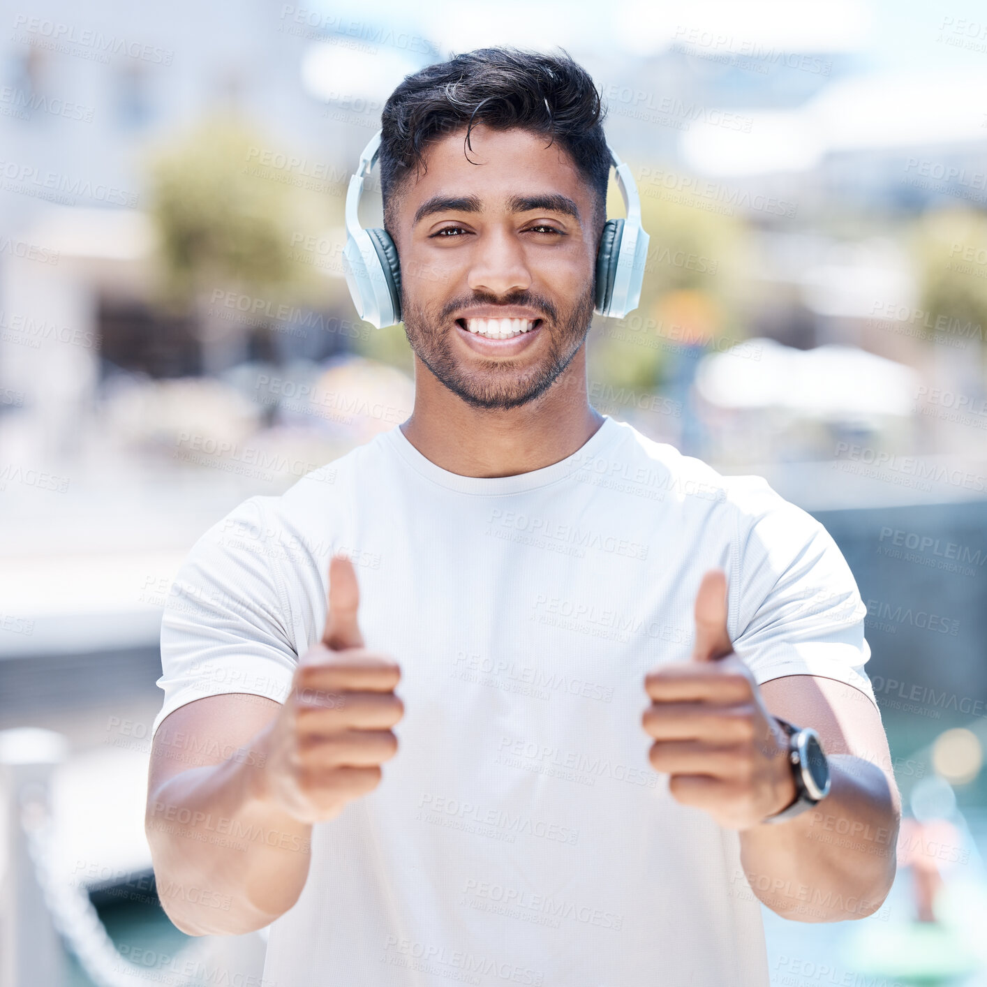 Buy stock photo Happy man, headphones and listening to music with thumbs up for winning, fitness or success in city. Portrait of male person, athlete or runner with headset, thumb emoji or yes sign for audio track