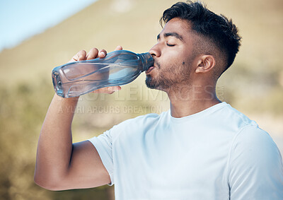 Buy stock photo Man, fitness and drinking water in nature for sustainability, running exercise or cardio workout outdoors. Thirsty male person, athlete or runner with drink for hydration, rest or break on mountain