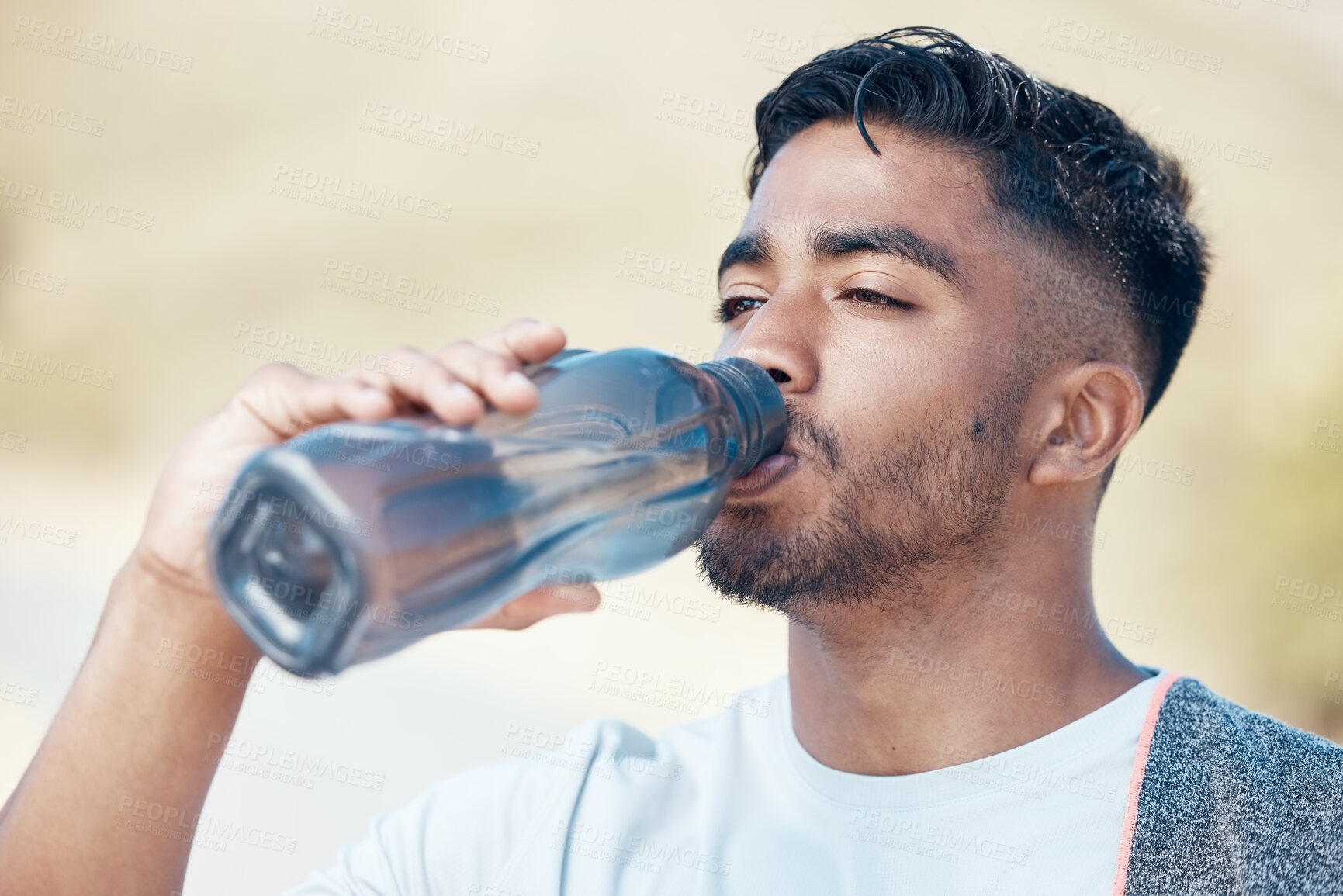 Buy stock photo Man, fitness and drinking water in nature for hydration, running exercise or cardio workout outdoors. Thirsty male person, athlete or runner with drink for sustainability, rest or break on mountain