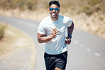Portrait of a mixed race handsome young man wearing sunglasses running alone outside during the day. Hispanic male exercising outside during a run in the road outdoors