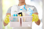 One unrecognizable woman holding cleaning supplies while cleaning her apartment. An unknown domestic cleaner wearing latex cleaning gloves and a collection of products