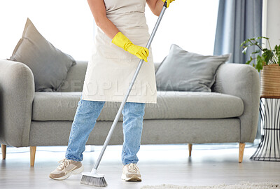 Buy stock photo Cleaning, broom and sweeping with a housekeeper in the living room of a home for housework or chores. Floor, sweep and housekeeping with a cleaner in a house to tidy for hygiene during a spring clean
