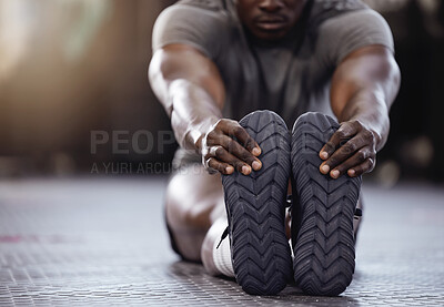 Buy stock photo Stretching, feet and exercise with a man at gym for fitness, muscle and training workout. Athlete person with hands on shoes for warm up, goals and performance motivation on floor at a wellness club 