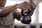 Closeup of unknown african american athlete lifting kettlebell during arm workout in gym. Strong, fit, active black man training with weights in health and sports club. Weightlifting exercise routine