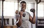Smiling young african american athlete lifting dumbbell during bicep curl workout in gym. Strong, fit, active black man training with weights in health and sport club. Weightlifting exercise routine
