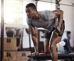 Serious african american athlete lifting dumbbell in tricep curl workout on bench in gym. Strong, fit, active black man training with weights in health and sport club. Weightlifting exercise routine