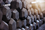 Closeup of stacked and piled heavy dumbbell weights arranged in empty gym with nobody during day. Weightlifting equipment organised in groups in health and sports centre with no one. Healthy routine