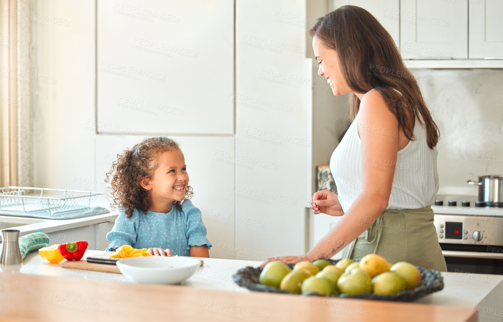 Buy stock photo Mother and little daughter talking while mom teach her how to cook a vegetarian meal. Cooking with a little helper