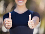 Close up of female hands showing thumbs up. Young female athlete gesturing with her hands while out for a workout. Sportswoman enjoying exercise outdoors