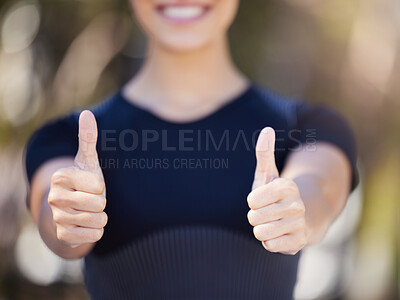 Close up of female hands showing thumbs up. Young female athlete gesturing with her hands while out for a workout. Sportswoman enjoying exercise outdoors