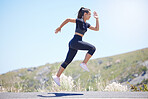 Young fit mixed race female running outside during a her daily exercise routine while jumping in mid air