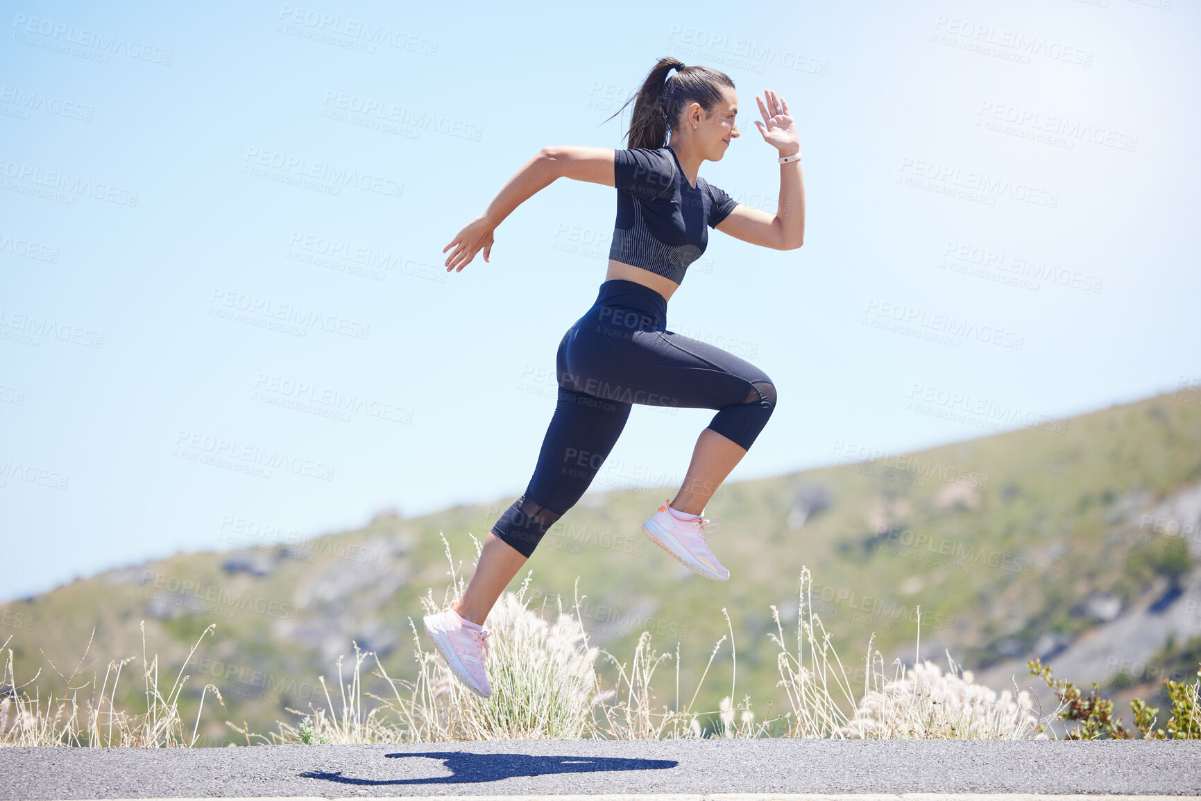 Buy stock photo Runner woman, street and jump with speed in nature, fitness and energy for training, wellness and healthy. Girl, fast running and air on road for self care, exercise and workout by hill in summer sun