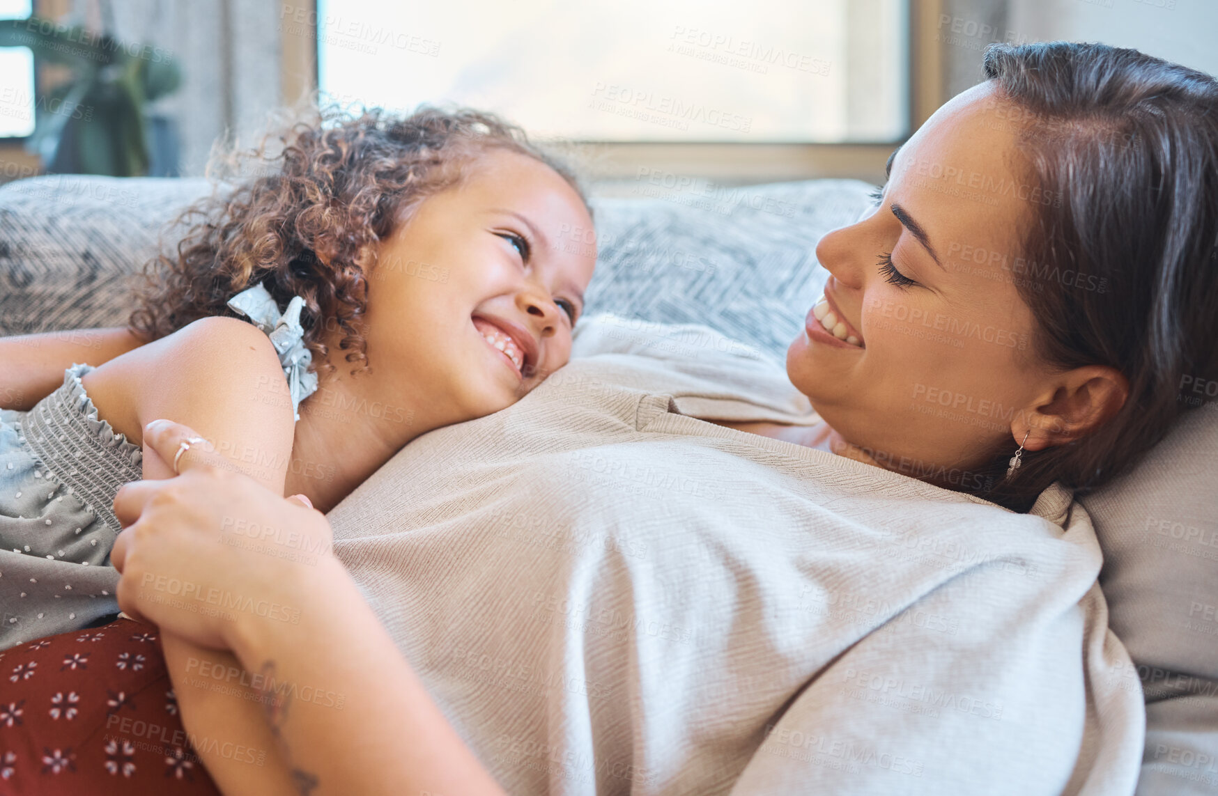 Buy stock photo Smile, relax and mom on sofa with child for morning bonding, laughing and humour in family home. Love, mother and daughter on couch with happy embrace, care and funny joke in living room together.