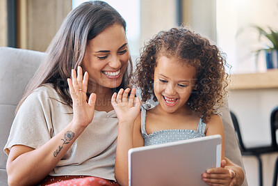 Buy stock photo Hispanic mother and little daughter waving with a hand gesture while using a digital tablet for a video call at home. Little girl and woman greeting someone on a call while smiling