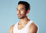 Handsome young hispanic man posing in studio isolated against a blue background. Mixed race male athlete wearing a vest and looking confident, healthy and fit. Exercising to increase his strength