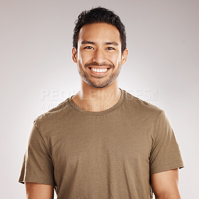 Buy stock photo Handsome young mixed race man smiling and happy while standing in studio isolated against a grey background. Hispanic male in casual wear expressing happiness with a smile and looking at the camera