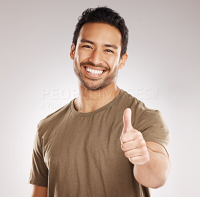 Buy stock photo Handsome young mixed race man giving thumbs up while standing in studio isolated against a grey background. Hispanic male showing support or appreciation. Backing or endorsing a product or company