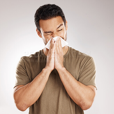 Buy stock photo Man sneezing, blowing nose and tissue with virus and health issue against a grey studio background. Male person, guy and model suffering from cold, sinus and hayfever with sickness and allergies