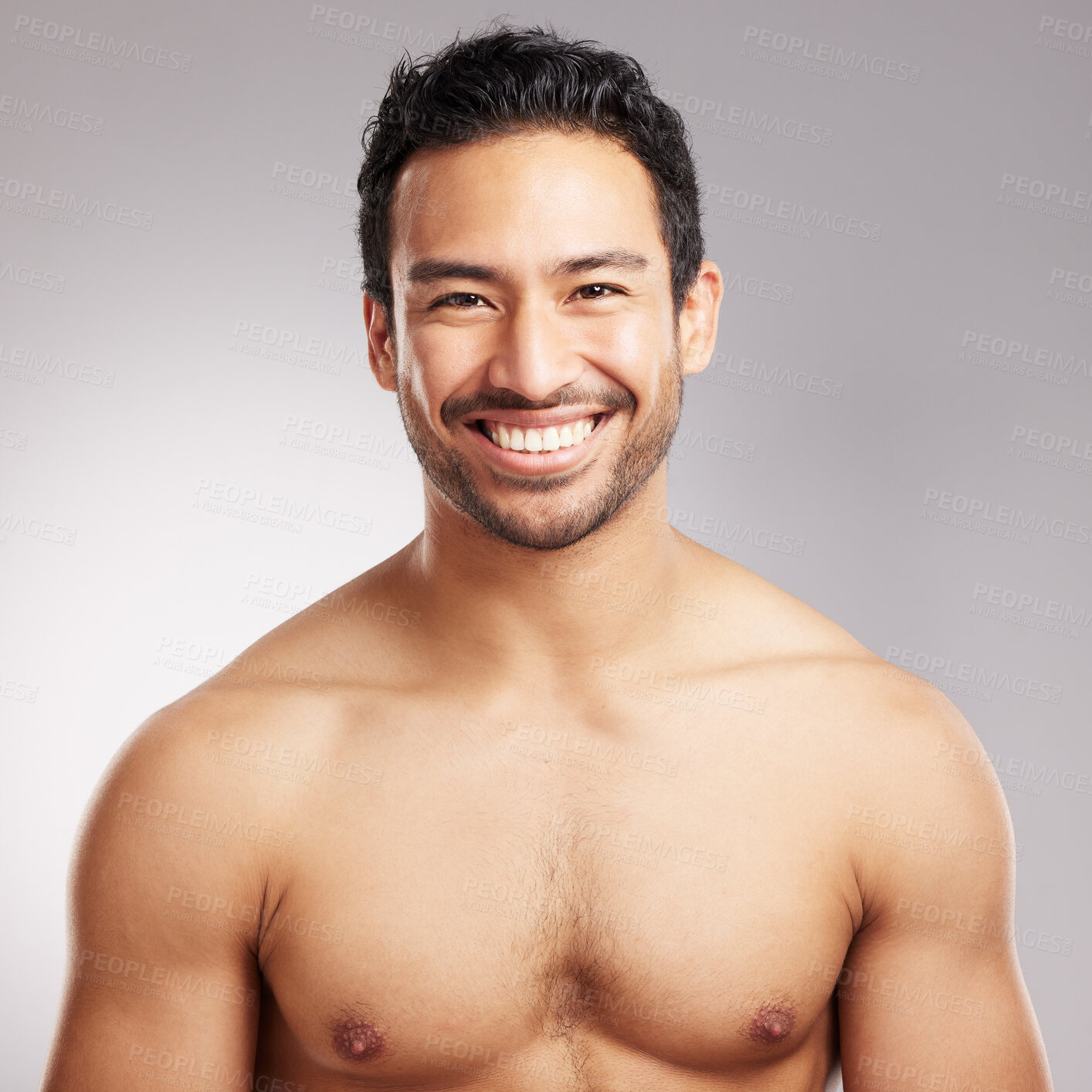 Buy stock photo Handsome young mixed race man shirtless in studio isolated against a grey background. Hispanic well groomed male looking confident and happy with his daily skincare regime. Firm and healthy skin