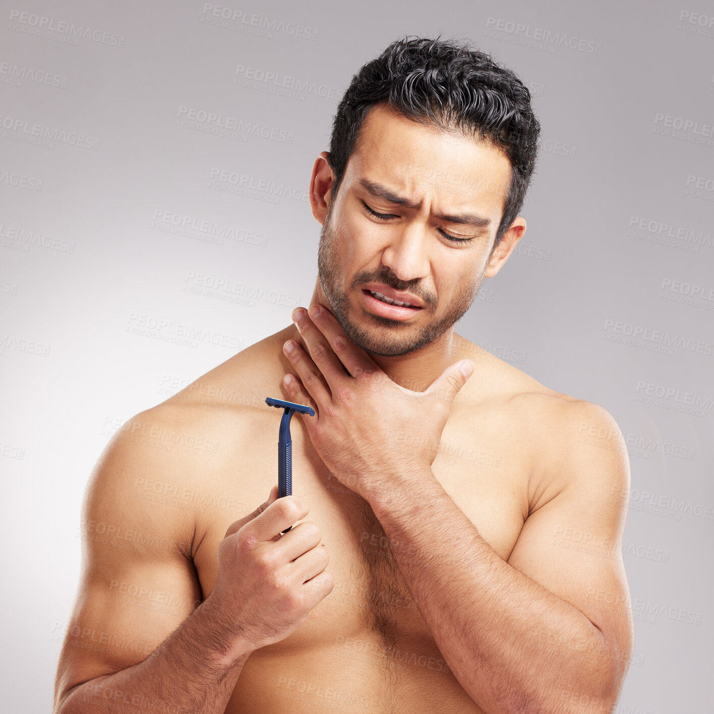 Buy stock photo Stress, shaving and man in studio, pain and wellness with grooming on gray background. Self care, person and model with beard beauty, routine and cleaning with facial razor, tool and sore with bruise