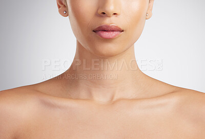 Buy stock photo Closeup of a beautiful mixed race woman's perfect neck and collar bone to model jewellery. A hispanic woman's flawless pout wearing pink lipgloss against grey studio copyspace background