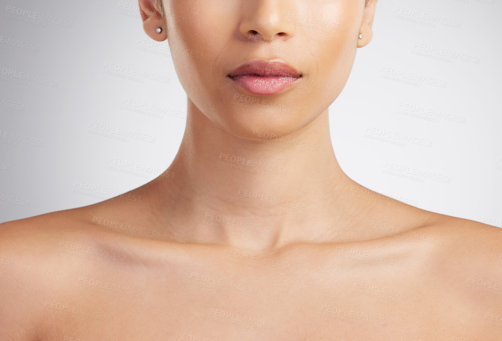 Buy stock photo Closeup of a beautiful mixed race woman's perfect neck and collar bone to model jewellery. A hispanic woman's flawless pout wearing pink lipgloss against grey studio copyspace background