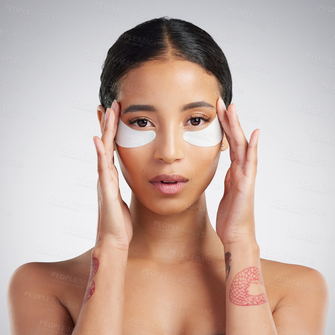 Buy stock photo Studio Portrait of a beautiful mixed race woman wearing under eye patches. Hispanic model with glowing skin using hydrating treatment against a grey copyspace background