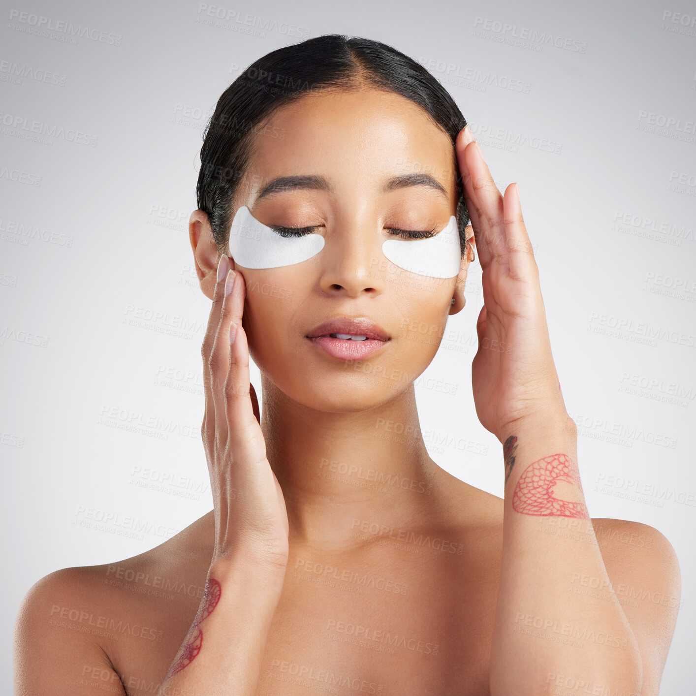 Buy stock photo A young beautiful mixed race woman wearing under eye patches. Hispanic model with glowing skin using hydrating treatment against a grey copyspace background