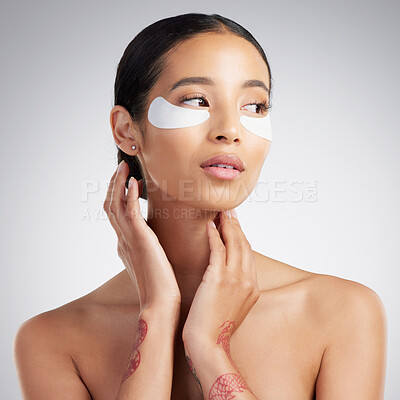 Buy stock photo A beautiful mixed race woman wearing under eye patches. Hispanic model with glowing skin using hydrating treatment against a grey copyspace background