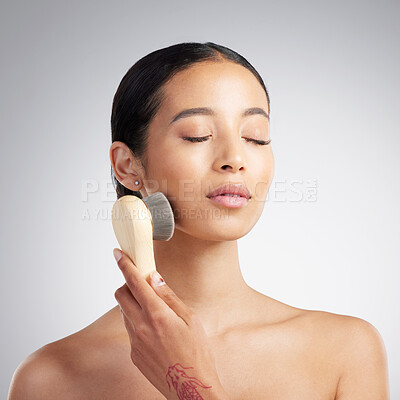 Buy stock photo A beautiful young mixed race woman with glowing skin using an anit ageing tool to exfoliate her smooth skin against a grey copyspace background