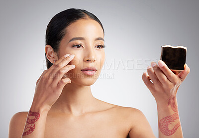 Buy stock photo A beautiful young mixed race woman with glowing skin posing against grey copyspace background. Hispanic woman checking her skin in the mirror for wrinkles and blemishes