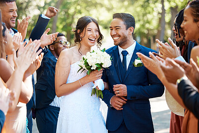 Buy stock photo Wedding guests clapping hands as the newlywed couple walk down the aisle. Joyful bride and groom walking arm in arm after their wedding ceremony