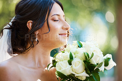 Buy stock photo Close up of a beautiful bride smelling her wedding bouquet.Tender bride standing outside on a sunny day and smelling wedding bouquet scent, White roses