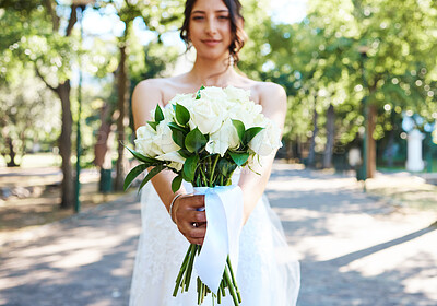 Buy stock photo Close up of bride holding a bouquet of flowers while standing outside on a sunny day. Beautiful wedding bouquet of white roses