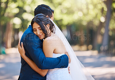 Buy stock photo Loving newlywed couple hugging each other. Bride and groom embracing each other feeling loved standing together against nature background