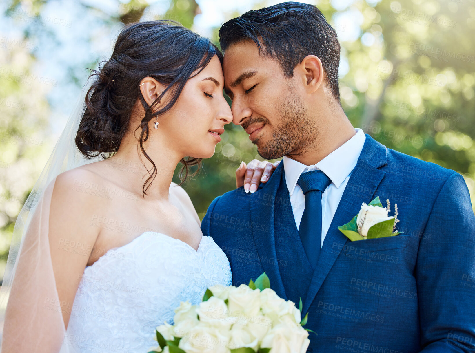 Buy stock photo Young bride and groom enjoying romantic moments outside on a beautiful summer day in nature. Newlywed couple touching foreheads while standing close