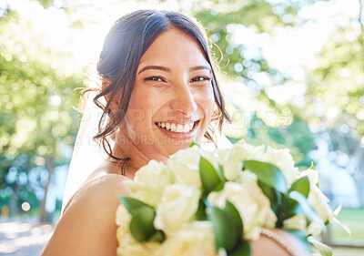 Buy stock photo Close up of a stunning bride smiling while holding a bouquet of white roses and standing outside on a sunny day. A happy bride on her wedding day