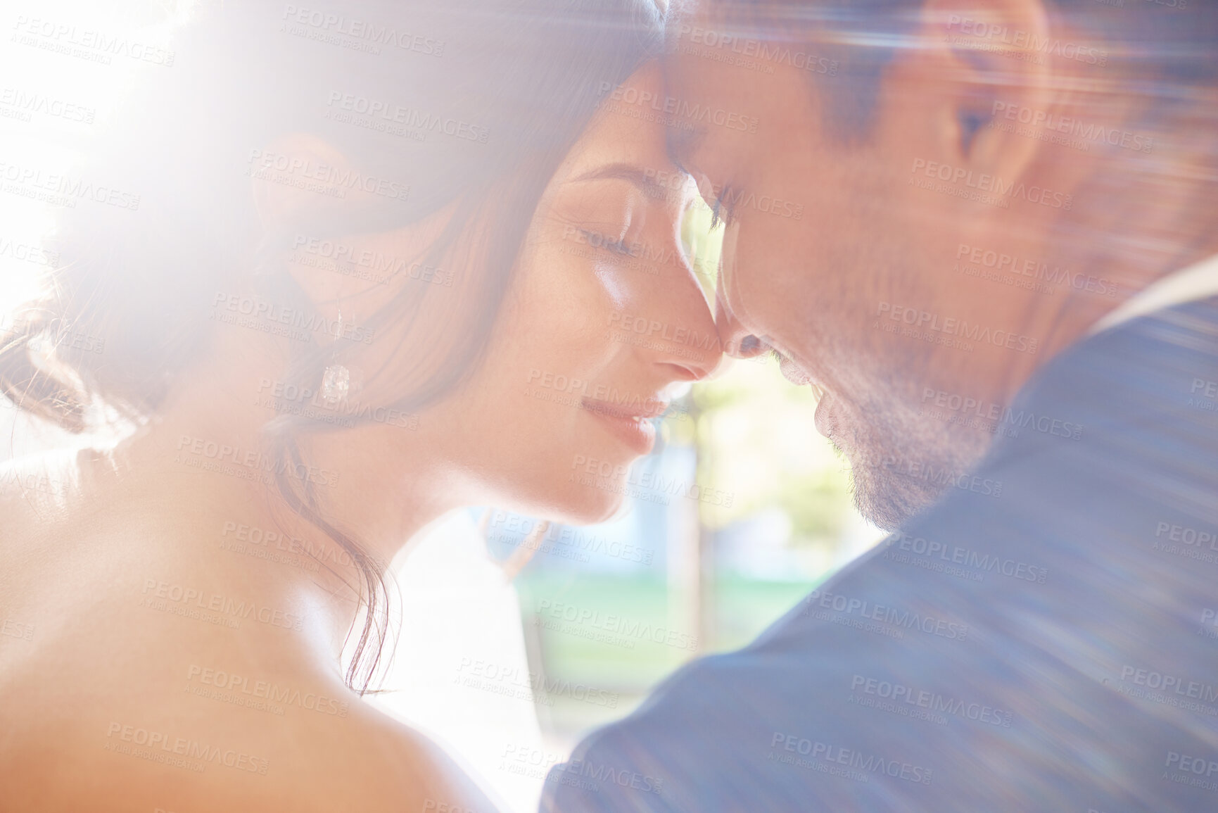 Buy stock photo Rear view of loving couple enjoying romantic moments on their wedding day. Newlywed couple touching foreheads while leaning against each other on a sunny day in nature