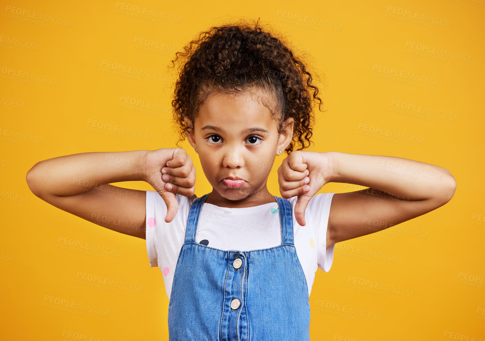 Buy stock photo Sad, negative and portrait of a child with a thumbs down isolated on a studio background. Unhappy, fail and a girl kid with an emoji hand sign for frustration, disappointment and disagreement